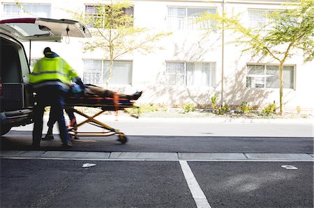 Ambulancemen carrying injured man on a stretcher Photographie de stock - Premium Libres de Droits, Code: 6109-08581797