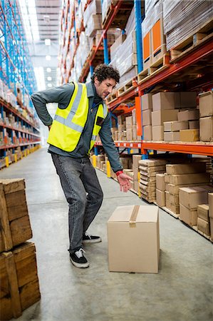 supplies (stock of essential items needed to sustain life) - Worker warehouse has back pain Foto de stock - Sin royalties Premium, Código: 6109-08581708