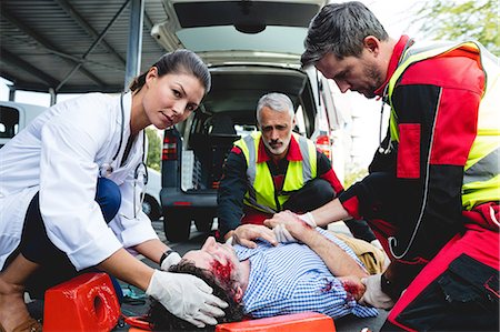 Injured man being healed by a team of ambulancemen Stock Photo - Premium Royalty-Free, Code: 6109-08581858