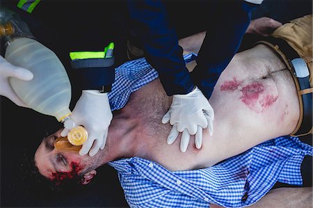 Injured man being healed by a team of ambulancemen Stock Photo - Premium Royalty-Free, Code: 6109-08581883