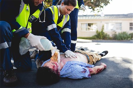 simsearch:6109-08581847,k - Injured man being healed by a team of ambulancemen Photographie de stock - Premium Libres de Droits, Code: 6109-08581882