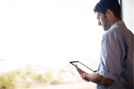 Rear view of creative businessman is looking a tablet Photographie de stock - Premium Libres de Droits, Code: 6109-08581889