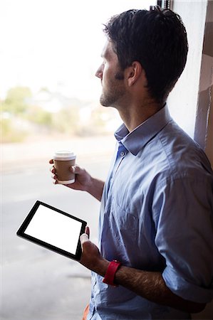 simsearch:6109-08581416,k - Profile view of businessman is holding a tablet and a coffee Stock Photo - Premium Royalty-Free, Code: 6109-08581890