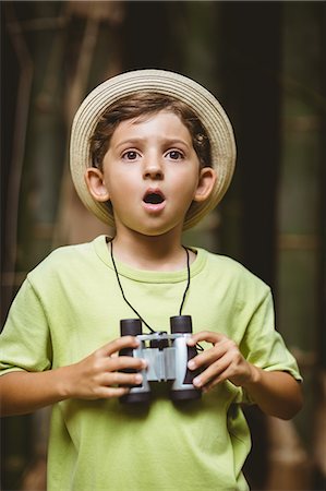 Young boy holding binoculars and making shocked expression Stock Photo - Premium Royalty-Free, Code: 6109-08581894