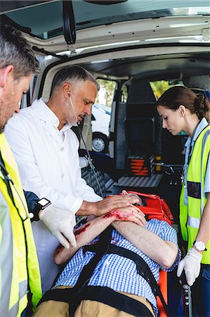 simsearch:6109-08689800,k - Ambulance men taking care of injured people on stretcher with doctor Photographie de stock - Premium Libres de Droits, Code: 6109-08581800