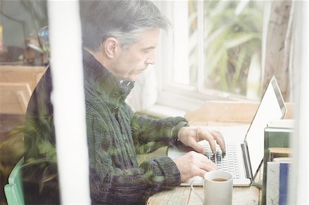 Profile of casual mature man working on laptop Stock Photo - Premium Royalty-Free, Code: 6109-08581972