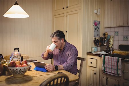 simsearch:6109-08582068,k - Mature man drinking while using tablet computer Stock Photo - Premium Royalty-Free, Code: 6109-08581977