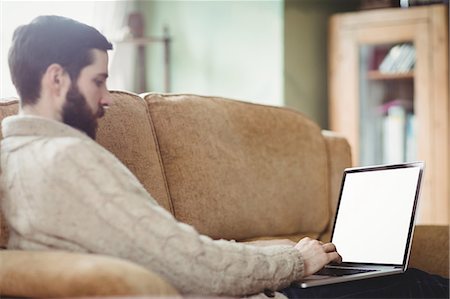 simsearch:6109-08582051,k - Profile view of hipster man using laptop in sofa Stock Photo - Premium Royalty-Free, Code: 6109-08581997