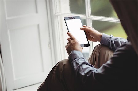 Cropped image of mature man using tablet computer Stock Photo - Premium Royalty-Free, Code: 6109-08582022