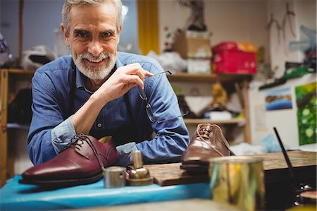 Cobbler smiling and posing without his glasses Stock Photo - Premium Royalty-Free, Code: 6109-08582162