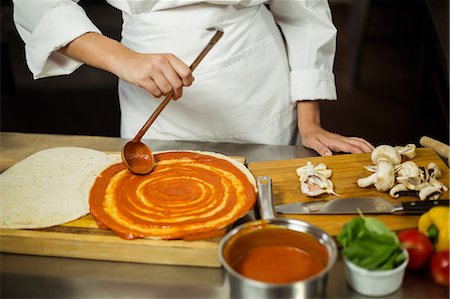 sauce in ladel - Mid section of head chef spreading sauce on a pizza Stock Photo - Premium Royalty-Free, Code: 6109-08582101