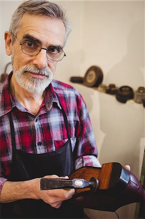 Portrait of cobbler holding a hammer and a shoe Photographie de stock - Premium Libres de Droits, Code: 6109-08582126