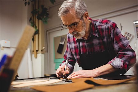 Concentrated cobbler drawing shoes Stock Photo - Premium Royalty-Free, Code: 6109-08582136