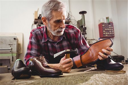 simsearch:6109-08705173,k - Cobbler hammering on the heel of a shoe Photographie de stock - Premium Libres de Droits, Code: 6109-08582249