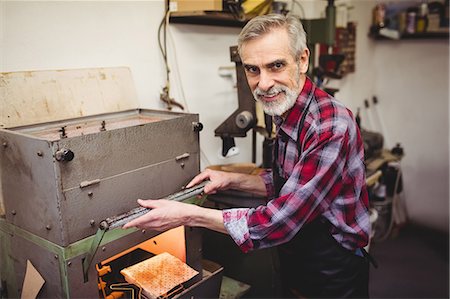 simsearch:6109-08705173,k - Portrait of cobbler smiling next to a machine Photographie de stock - Premium Libres de Droits, Code: 6109-08582265