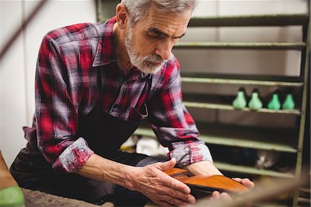 simsearch:649-06432882,k - Side view of cobbler checking a shoe Photographie de stock - Premium Libres de Droits, Code: 6109-08582282