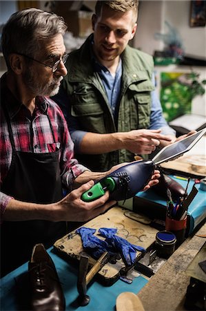 Cobbler showing the tablet computer to his colleague Foto de stock - Sin royalties Premium, Código: 6109-08582218