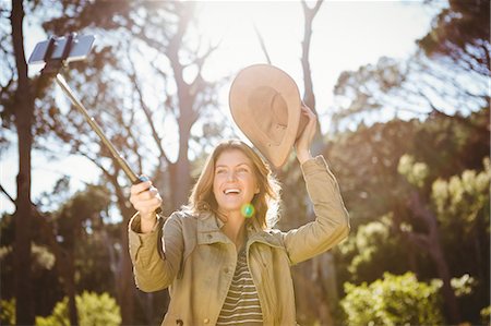 selfie stick - Woman taking a selfie Stock Photo - Premium Royalty-Free, Code: 6109-08536374