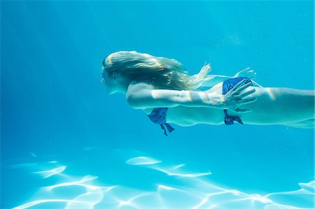debajo del agua - Smiling woman swimming underwater Foto de stock - Sin royalties Premium, Código: 6109-08536463