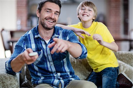 simsearch:6109-08536469,k - Father and son watching television in living room Stock Photo - Premium Royalty-Free, Code: 6109-08536481