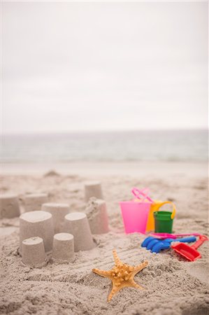 simsearch:6109-06003778,k - Sandcastle with bucket and spade at beach Photographie de stock - Premium Libres de Droits, Code: 6109-08536487