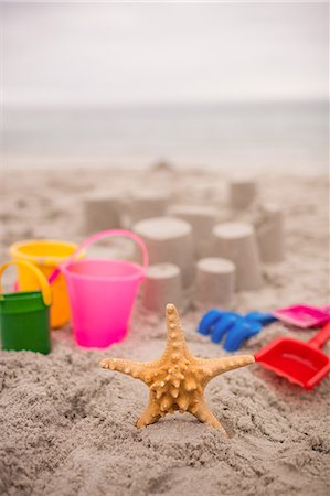 sea starfish pictures - Sandcastle with bucket and spade at beach Photographie de stock - Premium Libres de Droits, Code: 6109-08536488