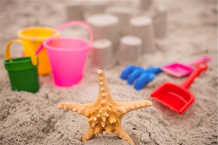 sea starfish pictures - Sandcastle with bucket and spade at beach Photographie de stock - Premium Libres de Droits, Code: 6109-08536489