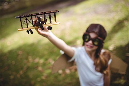 spielzeug - Girl playing with a toy aeroplane Foto de stock - Sin royalties Premium, Código: 6109-08536407