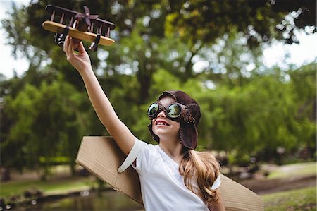 eyeglasses travel - Girl playing with a toy aeroplane Stock Photo - Premium Royalty-Free, Code: 6109-08536409