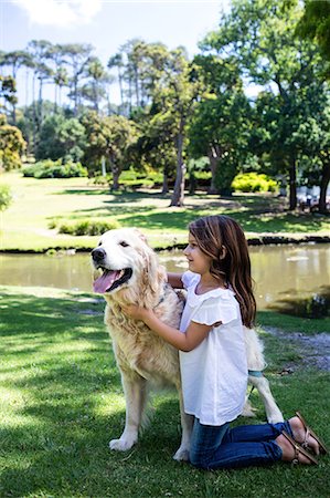 Smiling girl with her pet dog in the park Stock Photo - Premium Royalty-Free, Code: 6109-08536410