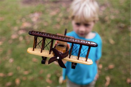 Boy playing with a toy aeroplane Foto de stock - Sin royalties Premium, Código: 6109-08536421