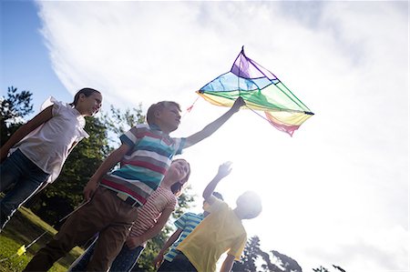 flying kites pictures - Happy children playing with a kite Stock Photo - Premium Royalty-Free, Code: 6109-08536431