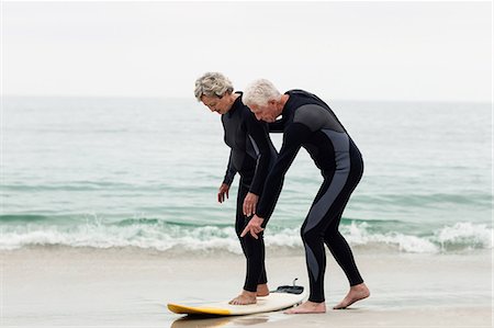 Senior man teaching woman to surf Photographie de stock - Premium Libres de Droits, Code: 6109-08536501