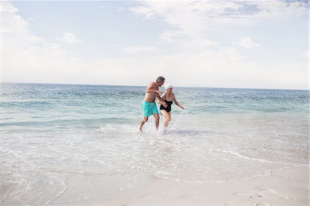 senior and sea - Senior couple holding hands and running on the beach Stock Photo - Premium Royalty-Free, Code: 6109-08536524