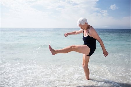 Happy senior woman splashing water with her feet Foto de stock - Sin royalties Premium, Código: 6109-08536525