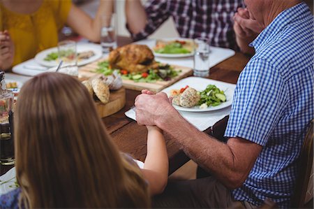 elderly parent with adult child - Family holding hands while praying Stock Photo - Premium Royalty-Free, Code: 6109-08536665