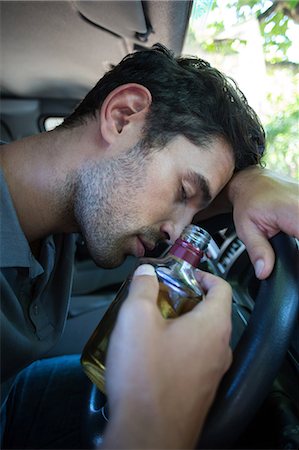 fahrer (fahrzeugführer - männlich) - Close-up of slumped man holding alcohol bottle Stockbilder - Premium RF Lizenzfrei, Bildnummer: 6109-08536699