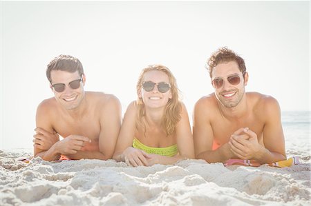 simsearch:6109-08536794,k - Happy friends lying on the beach Stock Photo - Premium Royalty-Free, Code: 6109-08536781