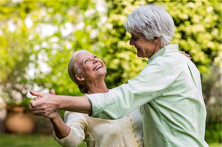 senior couple - Smiling senior woman looking up while dancing with man Stock Photo - Premium Royalty-Free, Code: 6109-08537047