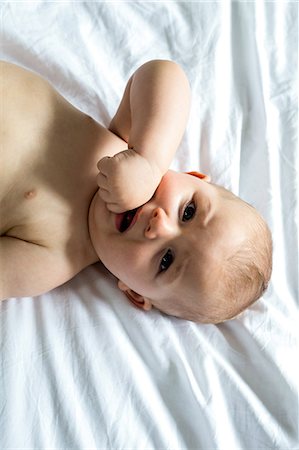Baby boy lying on bed at home Foto de stock - Sin royalties Premium, Código: 6109-08537060