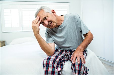 Frustrated senior man on bed at home Stock Photo - Premium Royalty-Free, Code: 6109-08537088