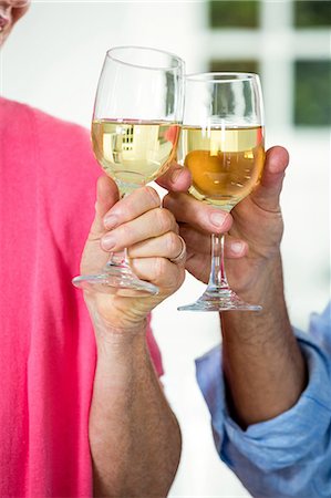 simsearch:6109-08804832,k - Cropped couple toasting white wine Stock Photo - Premium Royalty-Free, Code: 6109-08537094