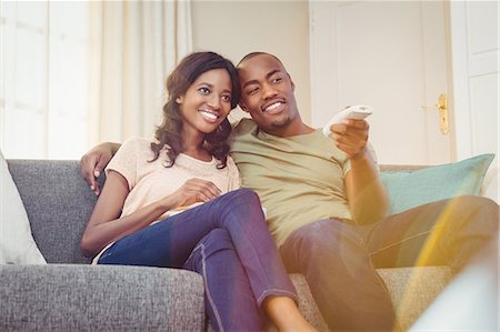 picture of a black man watching tv - Young couple relaxing on the sofa Stock Photo - Premium Royalty-Free, Code: 6109-08537014