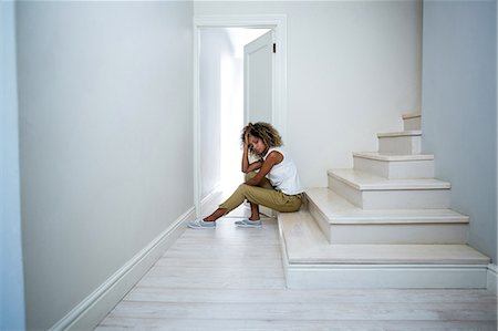 simsearch:6109-07497398,k - Tensed woman sitting on stairs Fotografie stock - Premium Royalty-Free, Codice: 6109-08537148