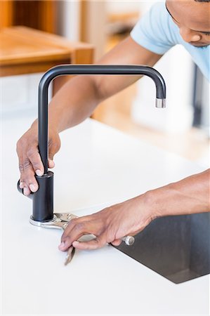 fixing sink - Man tightening tap with a wrench Stock Photo - Premium Royalty-Free, Code: 6109-08537123