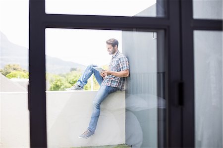 simsearch:6109-08537127,k - Man sitting on terrace using digital tablet Stock Photo - Premium Royalty-Free, Code: 6109-08537128