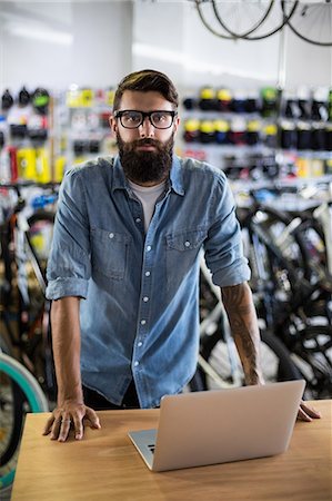 Bike mechanic checking at laptop Stock Photo - Premium Royalty-Free, Code: 6109-08537243