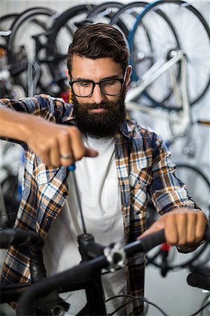 simsearch:6109-08537274,k - Bike mechanic checking at bicycle Stock Photo - Premium Royalty-Free, Code: 6109-08537265