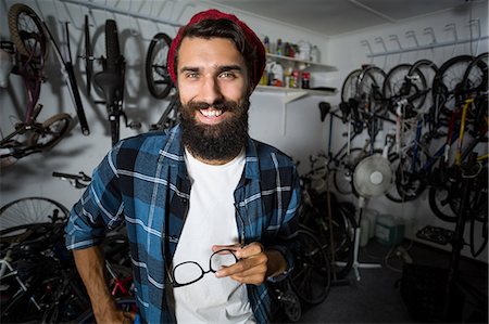 simsearch:6109-08537278,k - Bike mechanic holding glasses Stock Photo - Premium Royalty-Free, Code: 6109-08537292