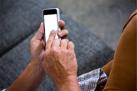 durchblättern - Mid section of man using mobile phone Stockbilder - Premium RF Lizenzfrei, Bildnummer: 6109-08537202